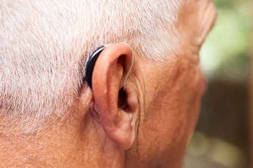 Man's head showing hearing aid.