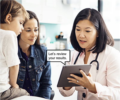 Doctor in clinic explaining results to family using auto generated captions on a tablet 