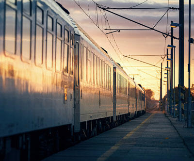 A train arriving at a train station at sunrise